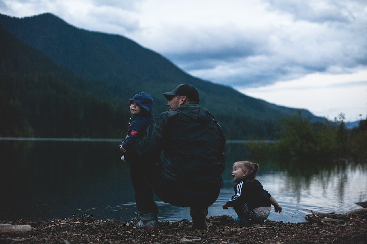 Un père avec ses enfants au bord du lac